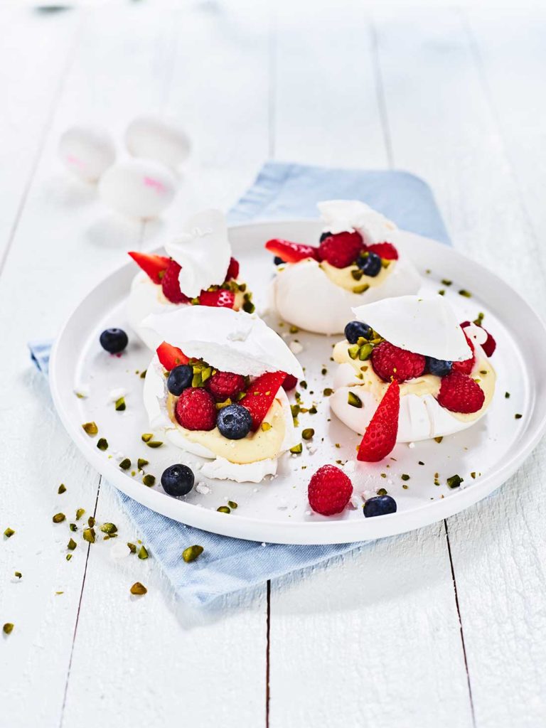 Pavlova med färska bär, vaniljkräm och pistage